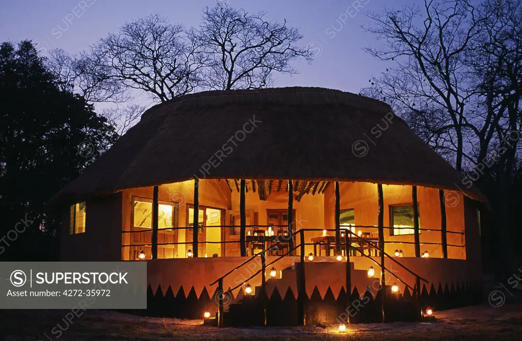 Zambia; Kasanka national park, Wasa lodge. New Bar, dining & lounge hut at Wasa Lodge, lit up in the evening.