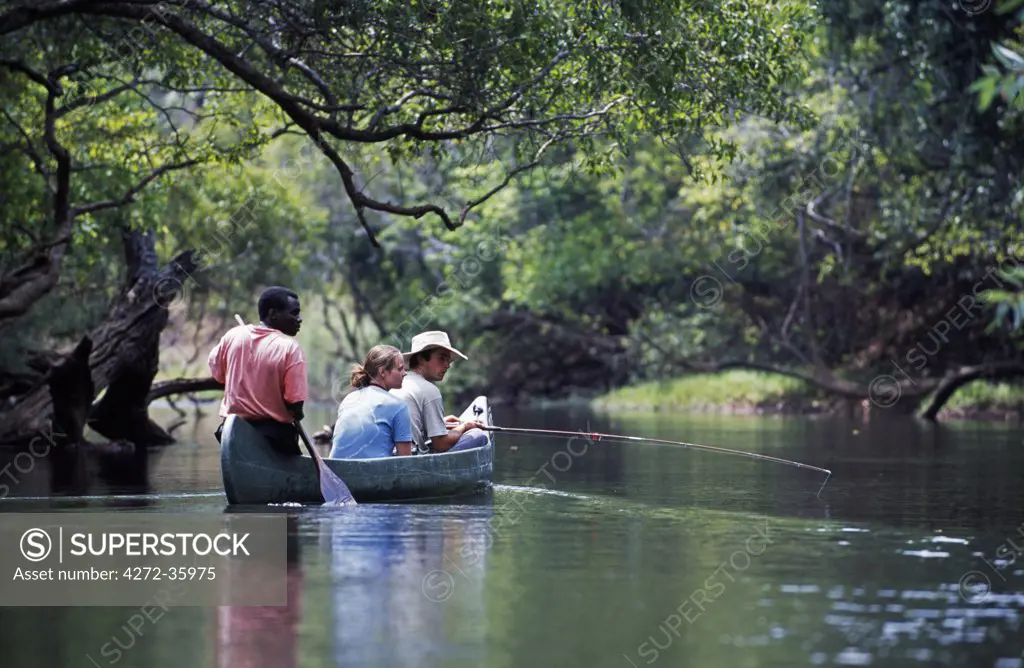 Zambia, Kasanka National Park. Canoeing on the Luwombwa River,  surrounded by riverine forest, with good birding and good fishing.