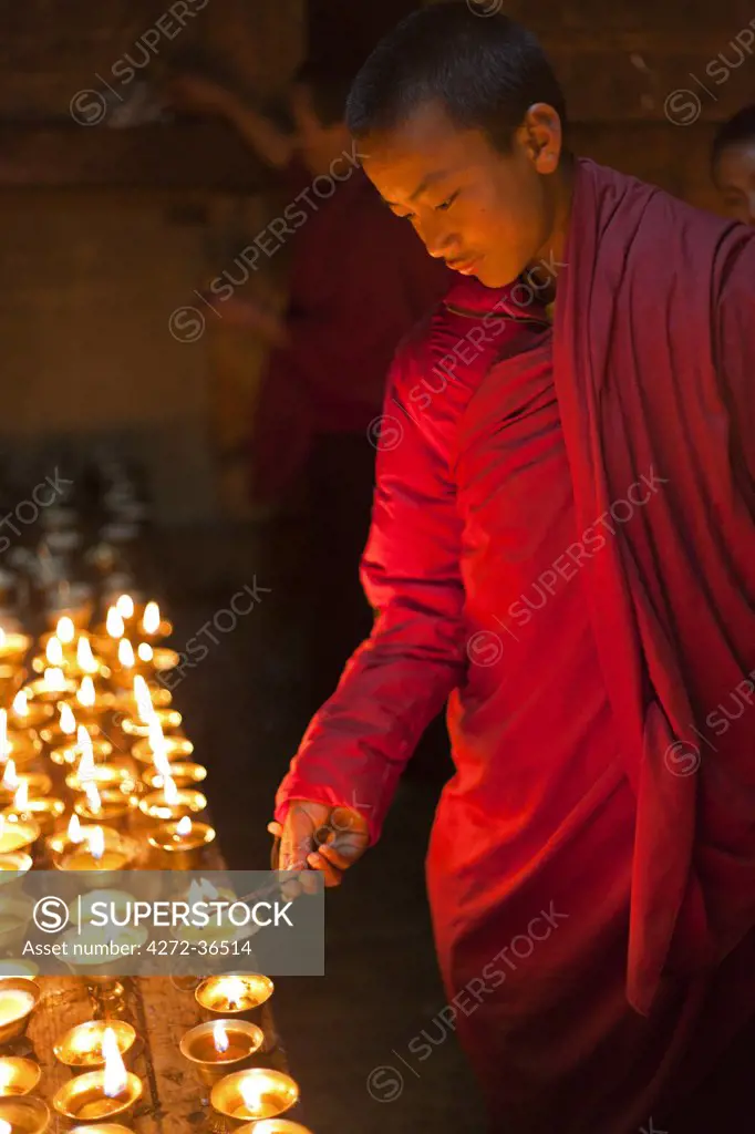 Young monk lighting butter lamps at Gangtey Gompa.