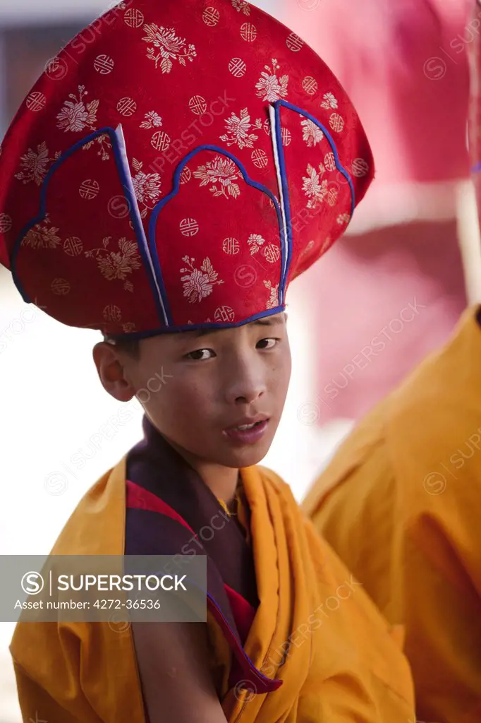 Young monk in ceremonial robes taking part in a puja in Gangtey Goemba.