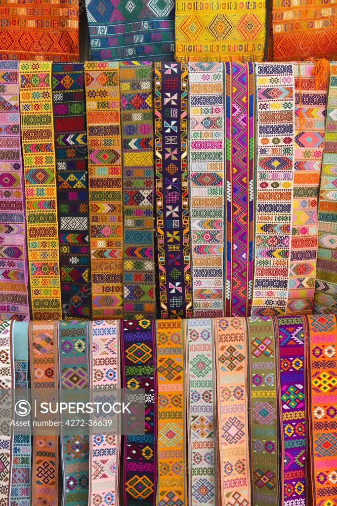 Bhutanese fabric belts used to secure a lady's kira around her waist, hanging up for sale in a shop.
