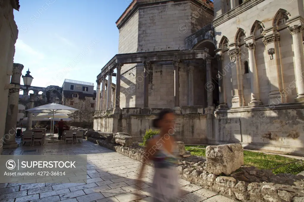 Croatia, Split, Central Europe. Young woman walking near the Cathedral and Diocletian palace. MR. UNESCO