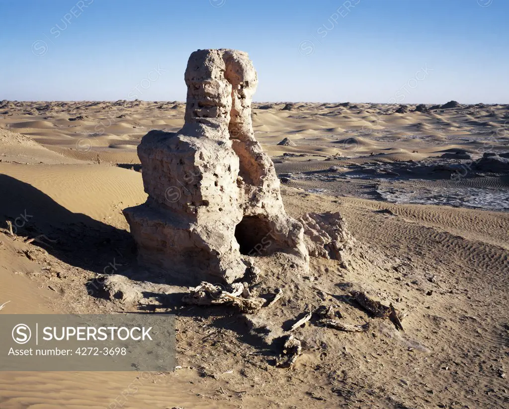 Remains of a Buddhist stupa, circa 3rd century Ad. Height 6 metres.  Niya, north of Minfeng.  This single ruined stupa of modest size stands at the centre of the site.  It was built of mud brick before 300AD and consists of a cylindrical dome on a square base.