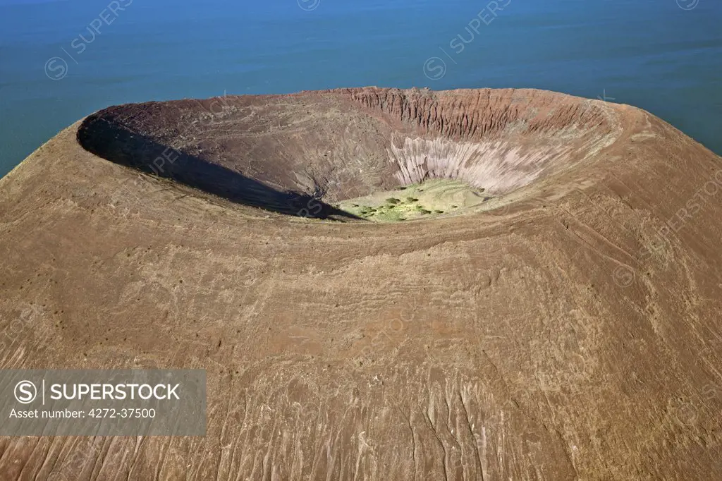 The perfectly shaped volcanic cone called Nabuyatom juts into the jade waters of Lake Turkana at the inhospitable southern end of the lake, known as Von Hohnel Bay.