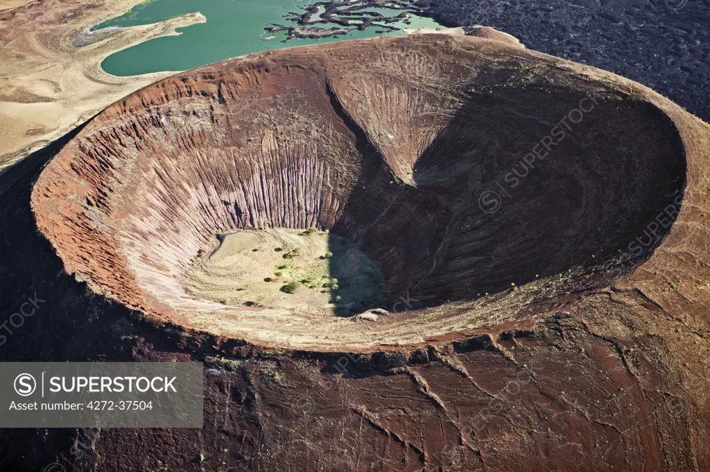 The perfectly shaped volcanic cone called Nabuyatom juts into the jade waters of Lake Turkana at the inhospitable southern end of the lake, known as Von Hohnel Bay.