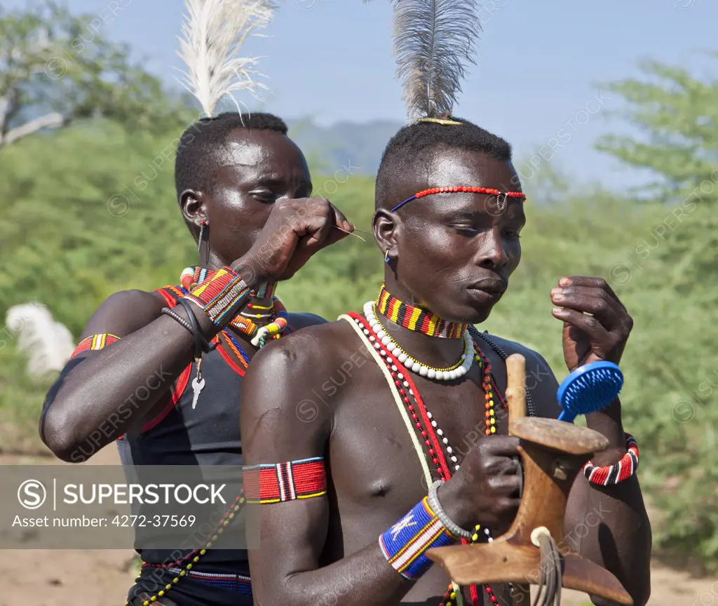 Pokot warriors attending a Sapana ceremony, put on their beaded ornaments prior to dancing.