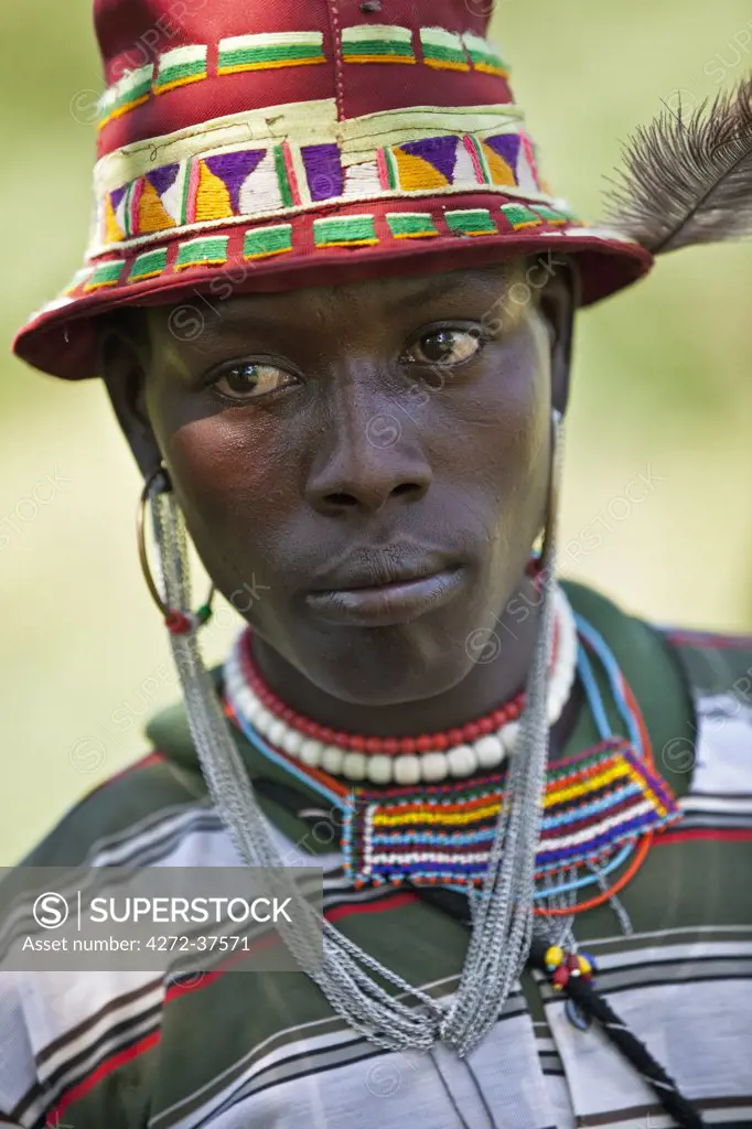 A Pokot warrior attending a Sapana ceremony, wears an interesting mixture of modern dress with traditional ornaments.
