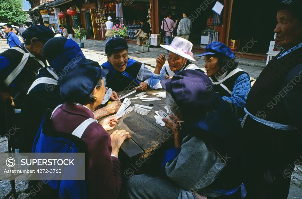 Naxi women play cards in the centre of Lijiang's old quarter. One of China's approximately fifty-six officially recognised minority nationalities, the Naxi traditionally had matriarchal society.