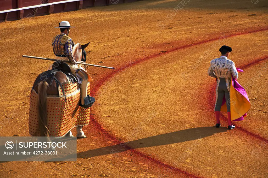Spain, Andalusia, Seville; A picador and a toreador observing the movements of the bull during a 'Corrida' in 'La Meastranza' bull ring - the oldest arena of the sort in the world