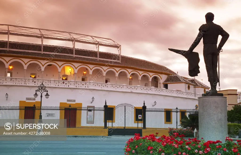 Spain, Andalusia, Seville; 'La Maestranza' bull-fighting arena, the oldest arena of its sort in the world, with a monument to a toreador in the foreground