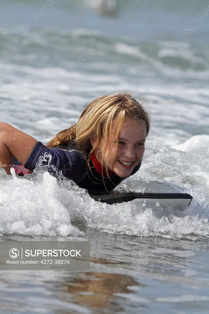 Girl body boarding in the surf, Pembrokeshire, Wales. MR
