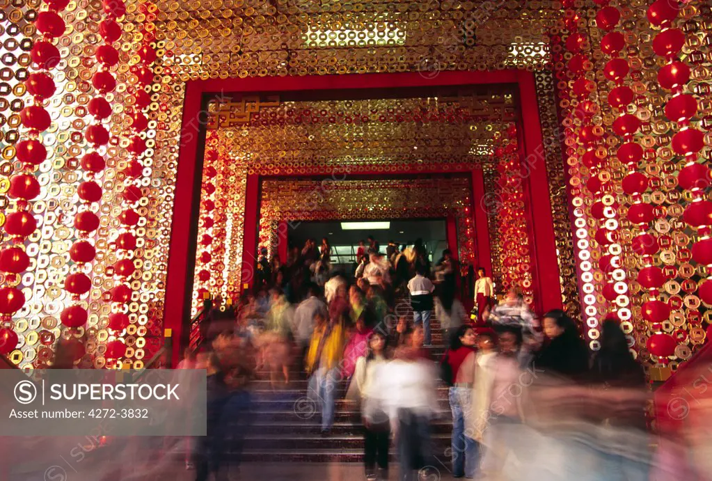 Visitors stream through the entrance to the Star House shopping centre, decorated for Chinese New Year. The shopping complex sits on Victoria Harbour next to the Ocean