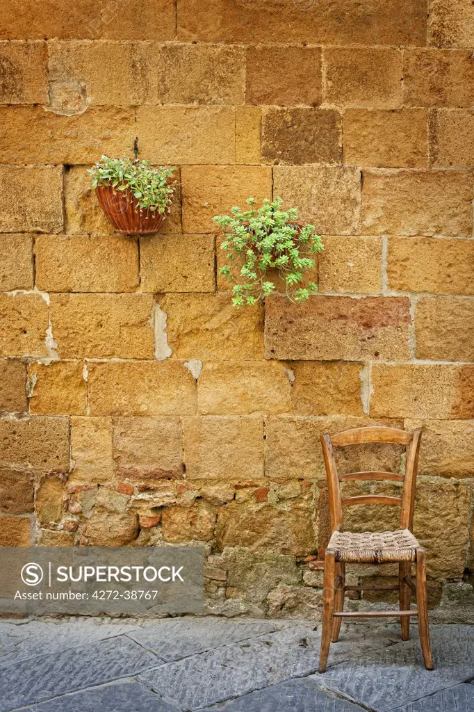 Italy, Tuscany, Siena district, Orcia Valley, wodden chair in a Pienza alley