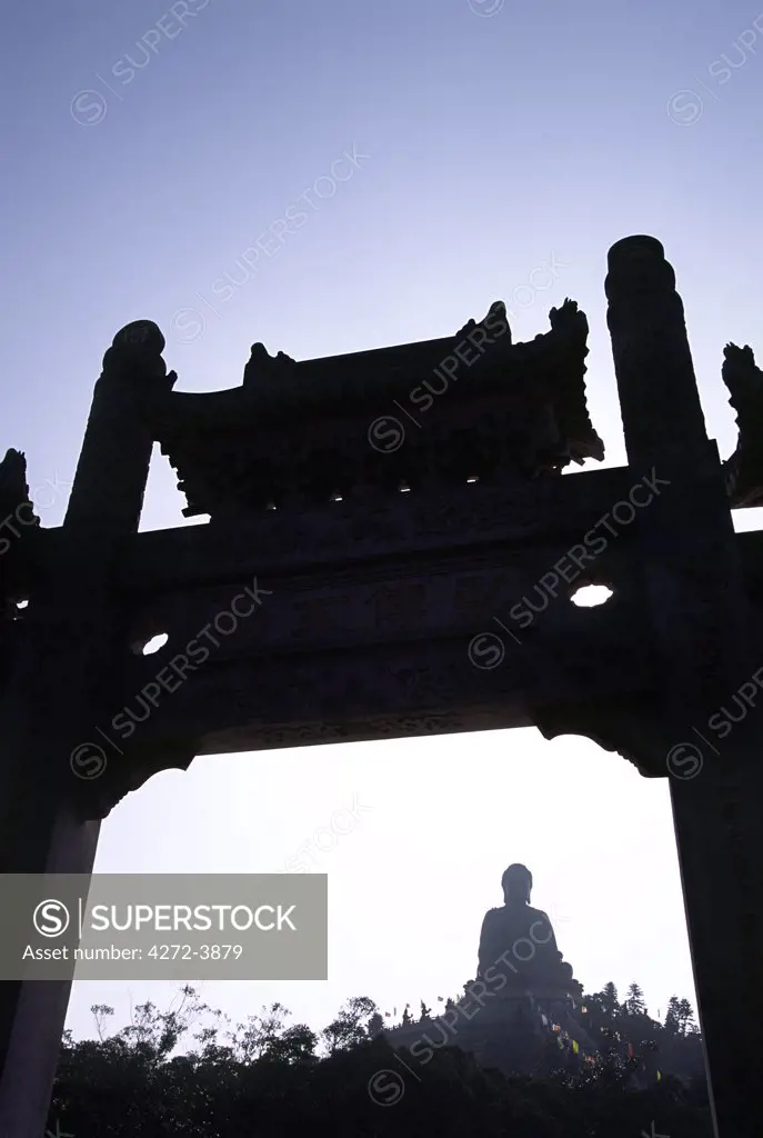 The giant bronze Tian Tan Buddha is framed by the gate to the Po Lin Monastery. The giant statue, a representation of Lord Gautama, sits on the Ngong Ping Plateau on Lantau Island, Hong Kong