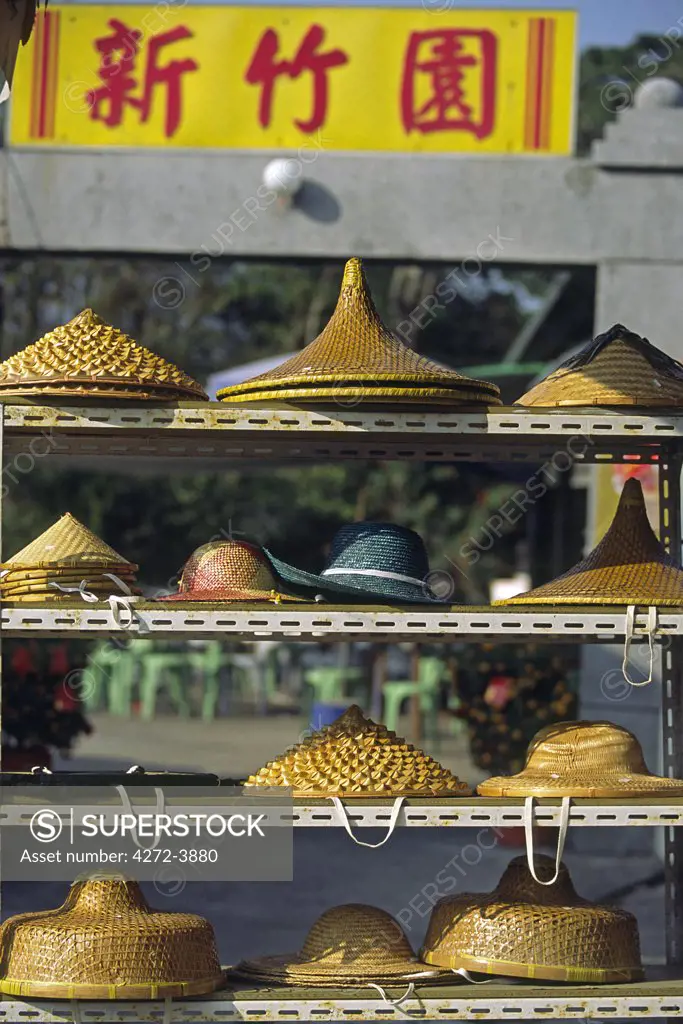 Hats woven from traditional materials sit in a market in Ngong Ping on Lantau Island, Hong Kong