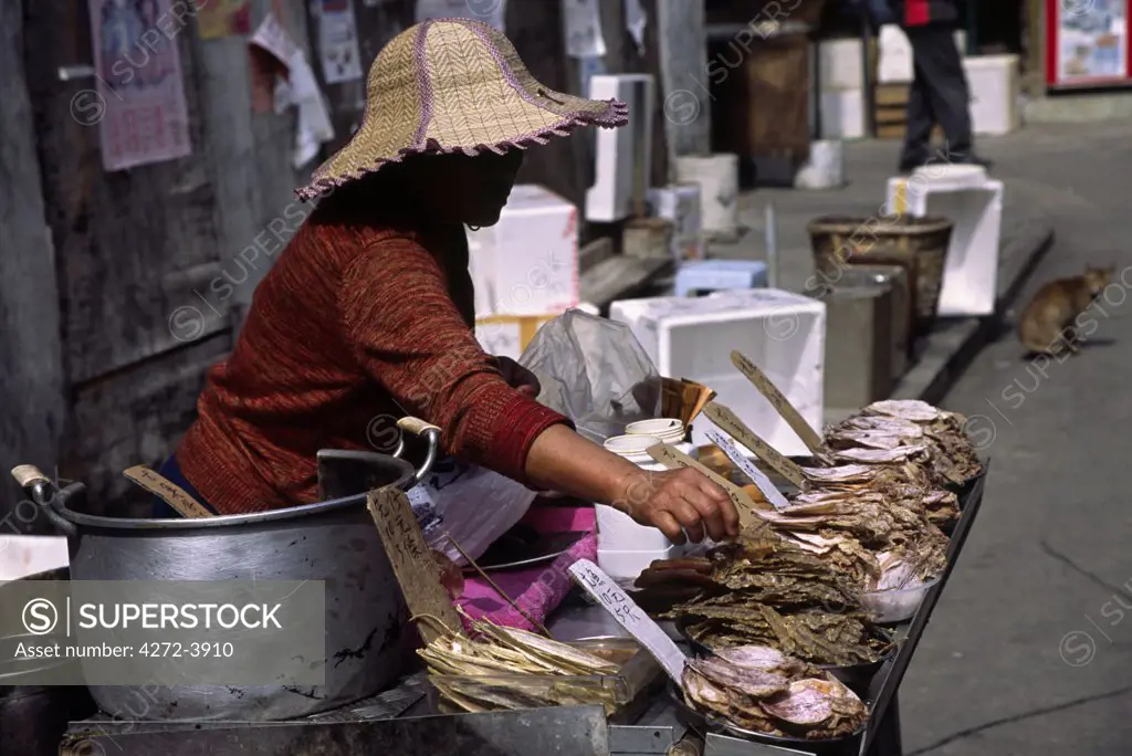 A woman lays out dried seafood to sell to visitors arriving at the Tanka village of Tai O on Lantau Island Hong Kong.