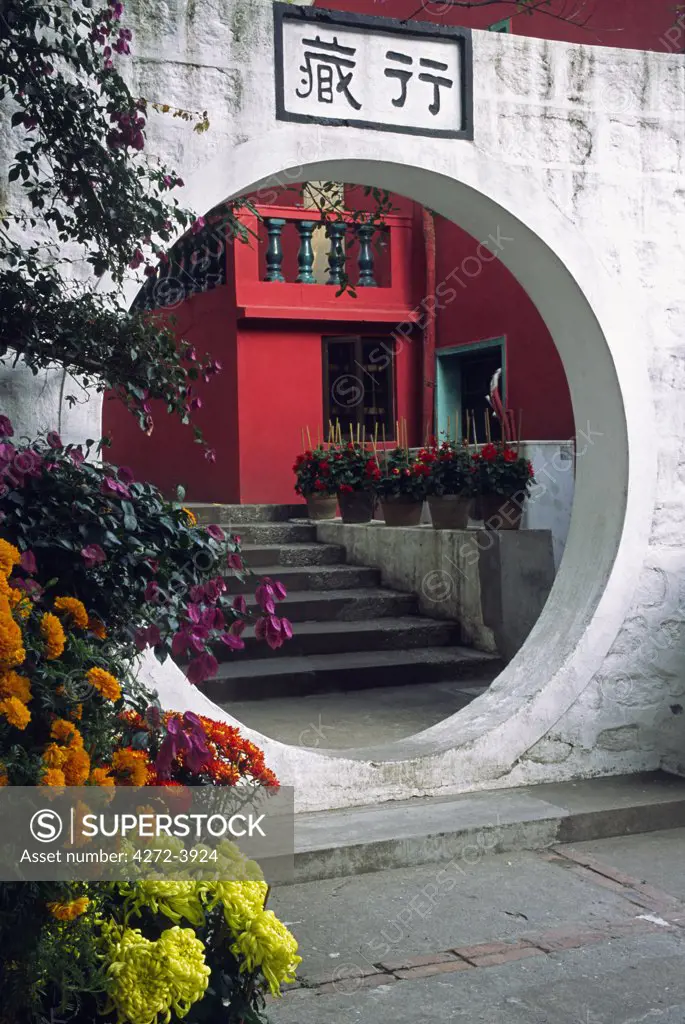 A decorative arch leads through to a flower garden in the Po Lin Monastery on Lantau Island, Hong Kong.