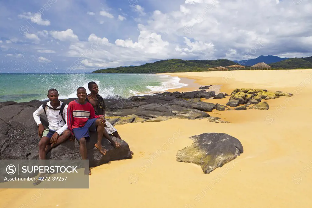 Africa, Sierra Leone, Freetown Peninsula, John Obey Beach. Boys sitting on rocks.