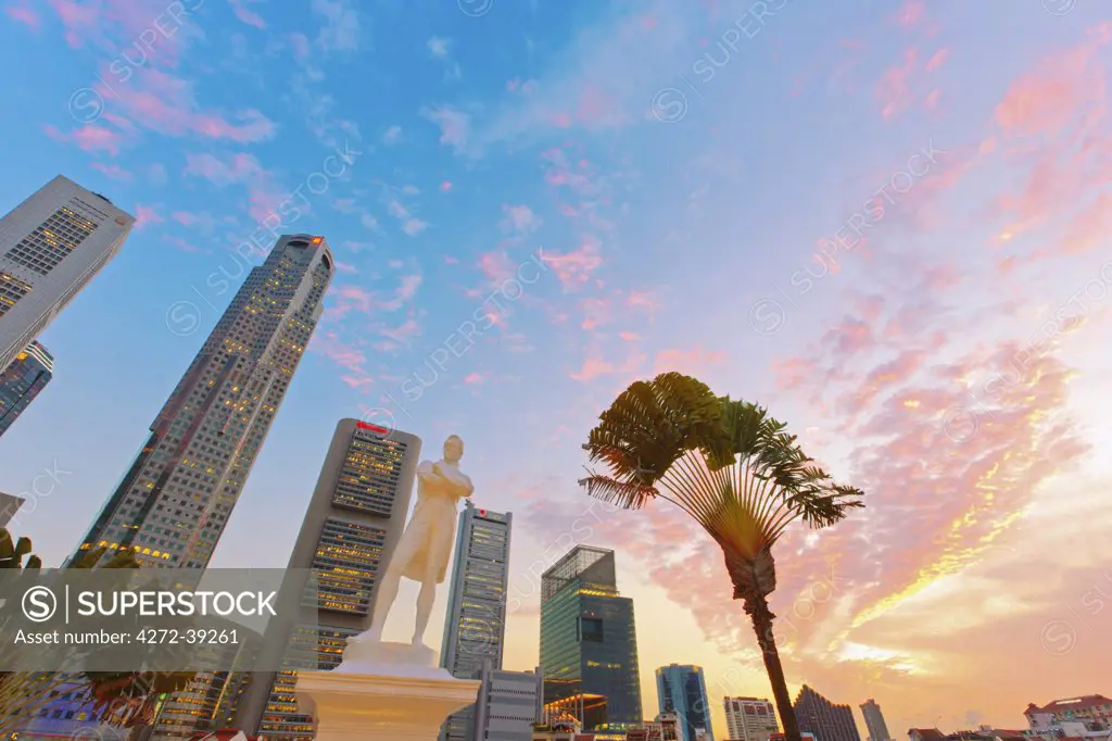 Singapore, Singapore City, Raffles statue and financial center behind at dusk