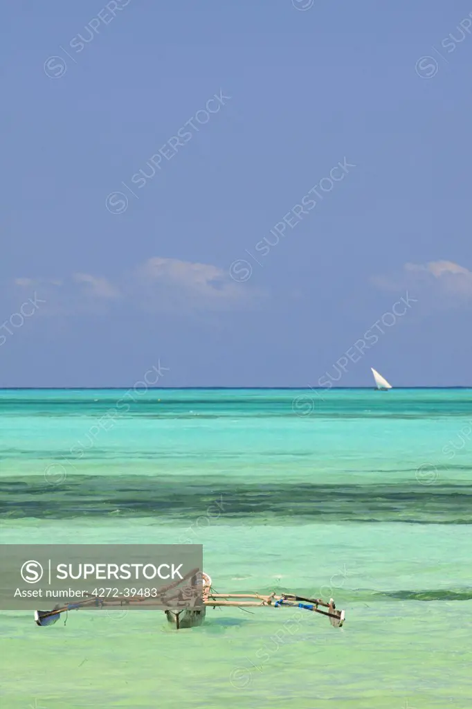 Tanzania, Zanzibar, Unguja, Jambiani. A traditional dhow moored near the shore.
