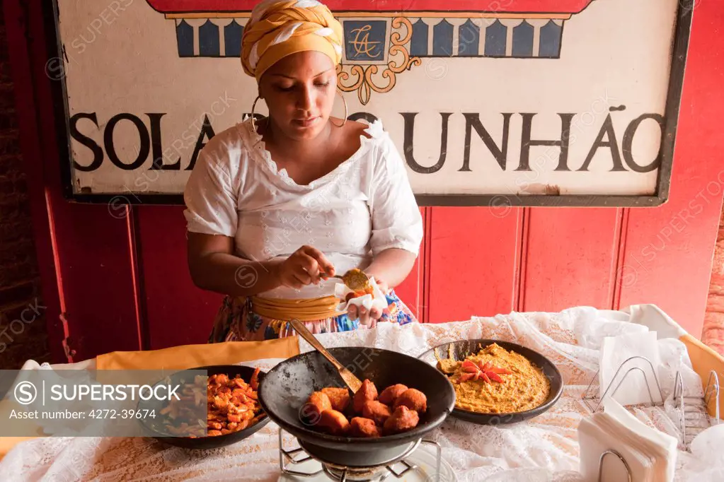Brazil, Food, a Baiana woman serves Bahian food  vatapa, acaraje and fried shrimp