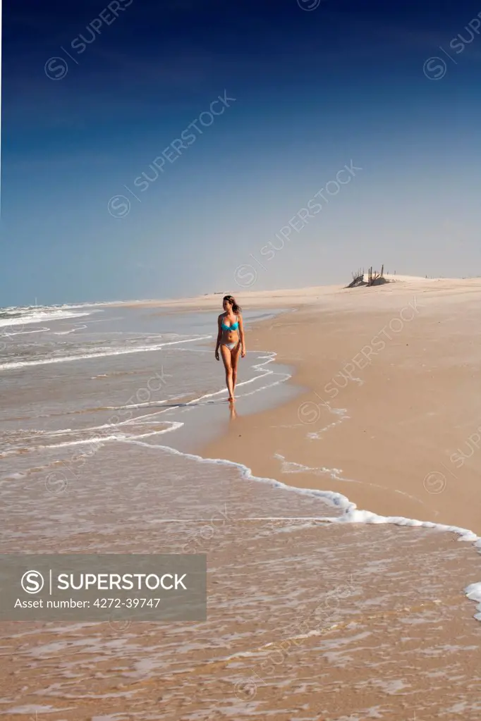 South America, Brazil, Maranhao, girl in a bikini walking along the beach in Cabure village in the Lencois Maranhenses national park MR