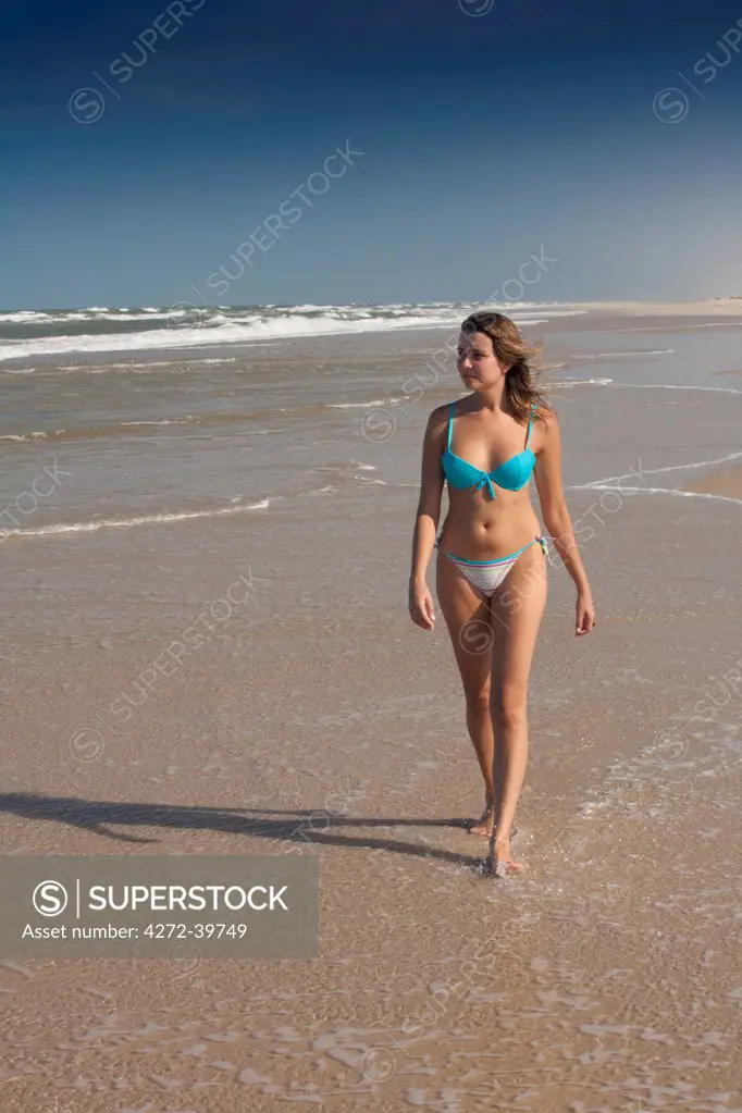 South America, Brazil, Maranhao, girl in a bikini walking along the beach in Cabure village in the Lencois Maranhenses national park MR