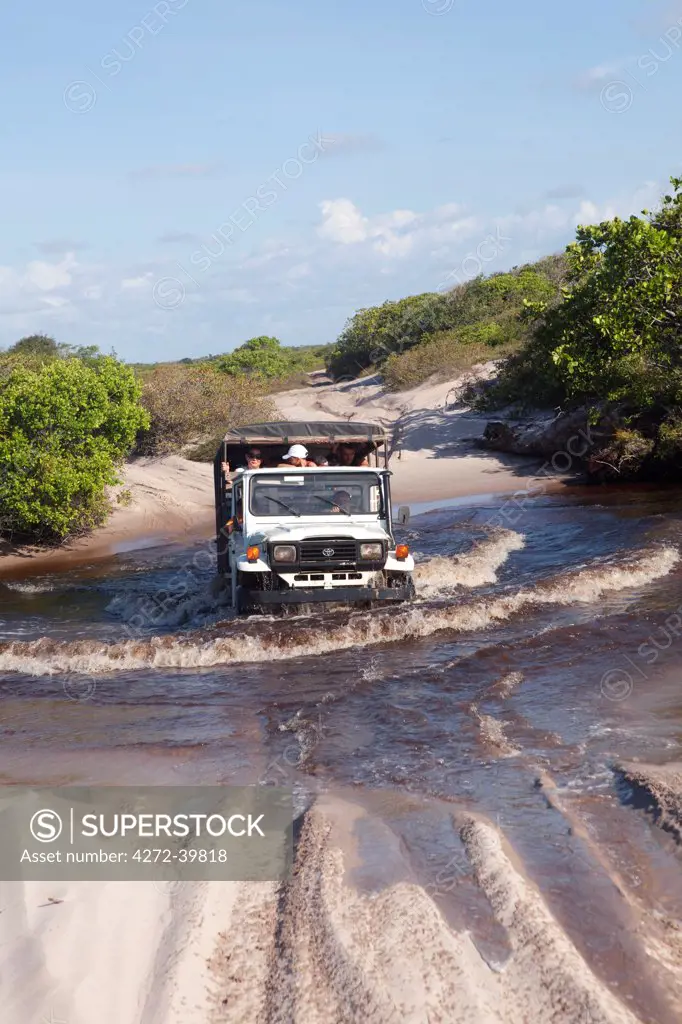 South America, Brazil, Maranhao, Parque Nacional dos Lencois Maranhenses, a Toyota Bandeirante crosses a black water creek in the Lencois Maranhenses National Park