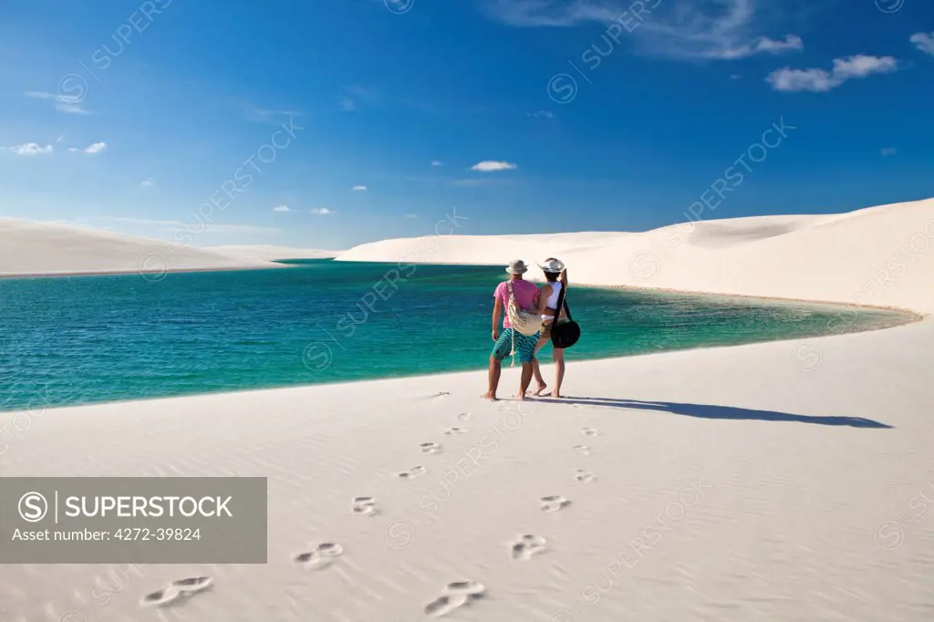 South America, Brazil, Maranhao, a honeymoon couple look out over a scene of dunes and lakes in the Lencois Maranhenses