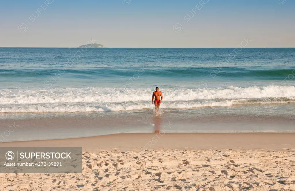 South America, Rio de Janeiro, Rio de Janeiro city, a man in a red sunga, speedos,  on Copacabana Beach