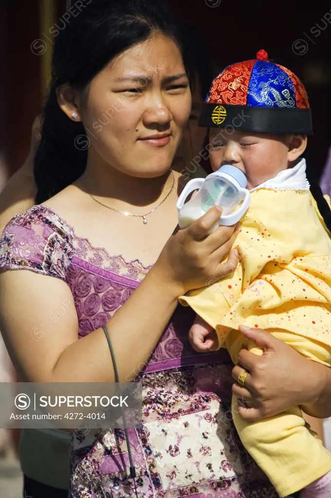 A mother and baby dressed in traditional Chinese clothes at The Temple of Heaven, Beijing, China