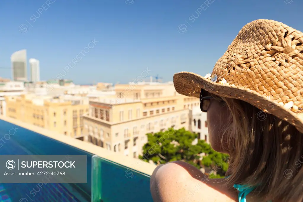 Lebanon, Beirut. A woman looks out over Beirut from the rooftop pool of the Le Gray Hotel. MR.