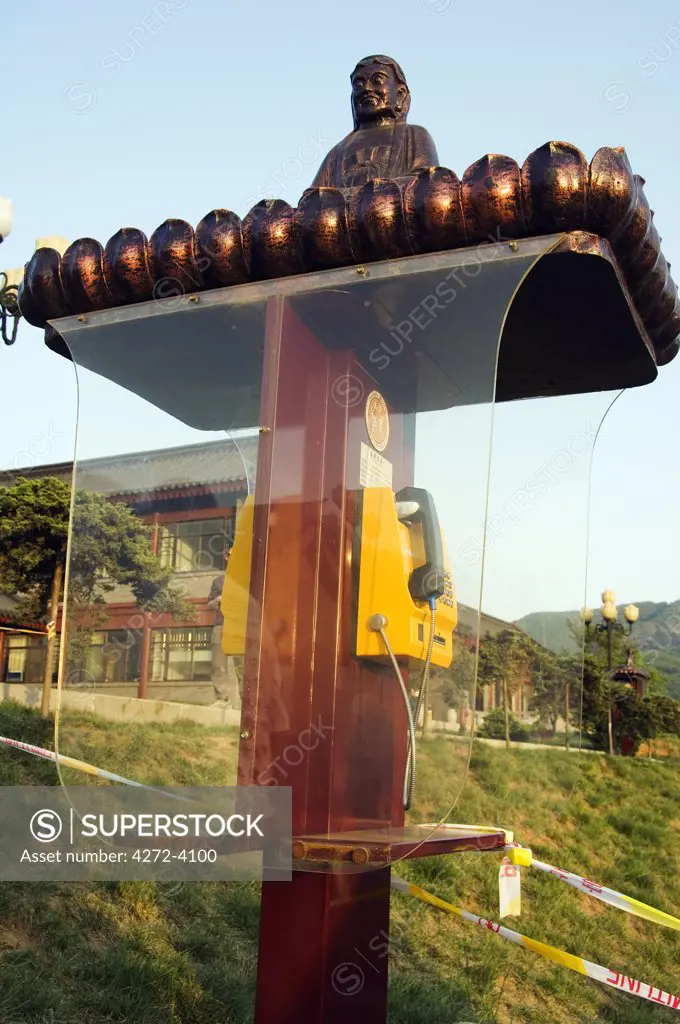 A Buddha decorates a telephone box at Shaolin temple birthplace of Kung Fu martial arts, Henan Province, China
