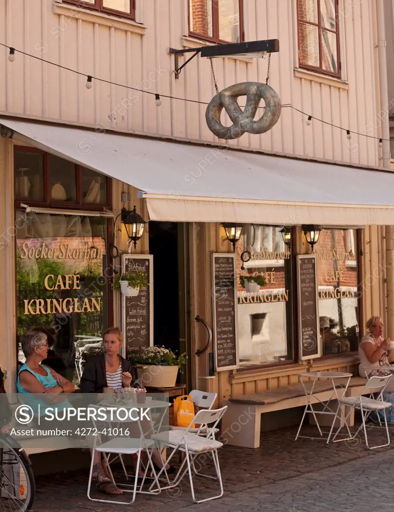 Gothenburg, Sweden. A pair of locals drink coffee outside a cafe and bakery in Gothenburgs old town.