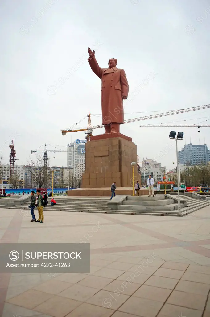 China, Dandong, North Korea Border, China Rising a Giant Mao statue with construction cranes in the background