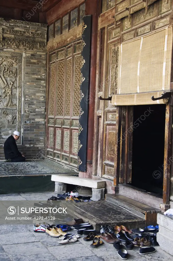 A man praying at The Great Mosque located in the Muslim Quarter, home to the city's Hui community, Xian City, Shaanxi Province, China