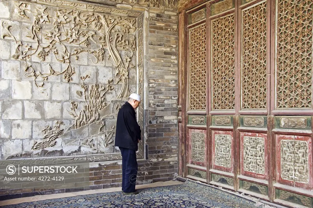 A man praying at The Great Mosque located in the Muslim Quarter, home to the city's Hui community, Xian City, Shaanxi Province, China