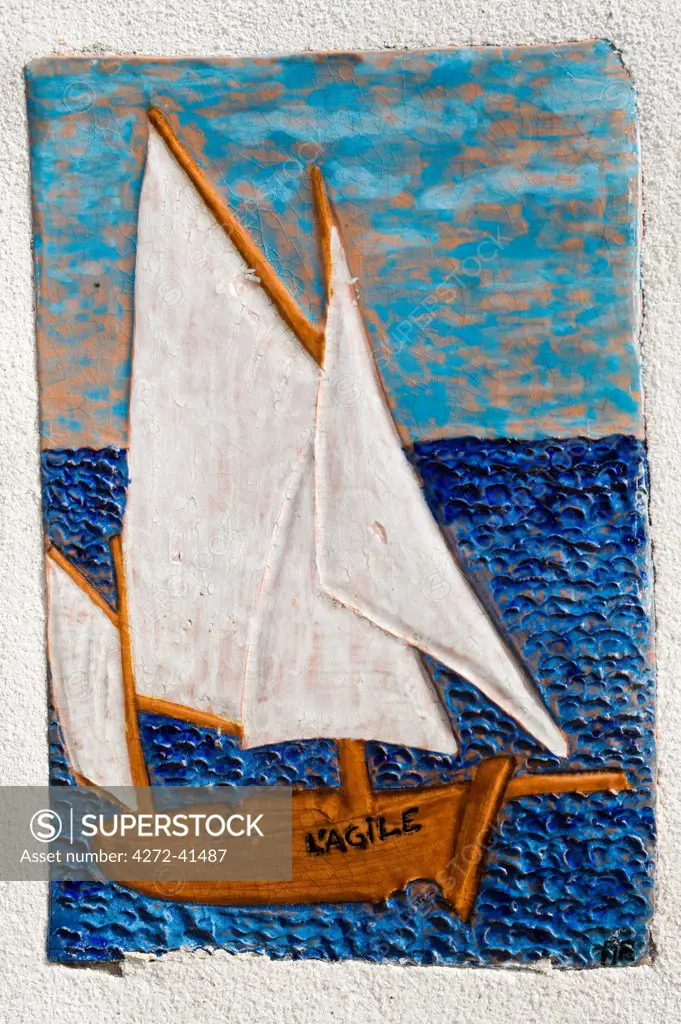 France, Charente Maritime, Ile de Re.  Ceramic tile depicting a sailing boat on a wall of a house in St Martin.