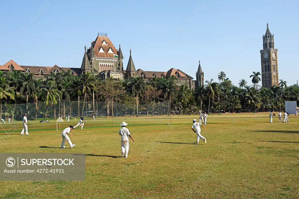 India, Mumbai. Backed by the Mumbai High Court and the Rajabai Clock Tower, impromptu cricket matches are a common sight in elongated city centre park called Oval Maidan.