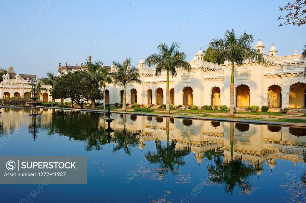 India, Andhra Pradesh, Hyderabad.  Palm trees stand reflected in the water tank of the gardens at Chowmahalla Palace which is now open to the public as a museum.