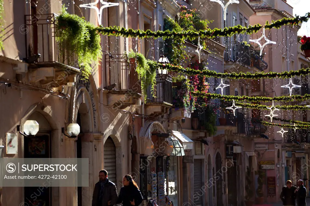 Taormina, Sicily, Italy, A couple walking through the main street in town