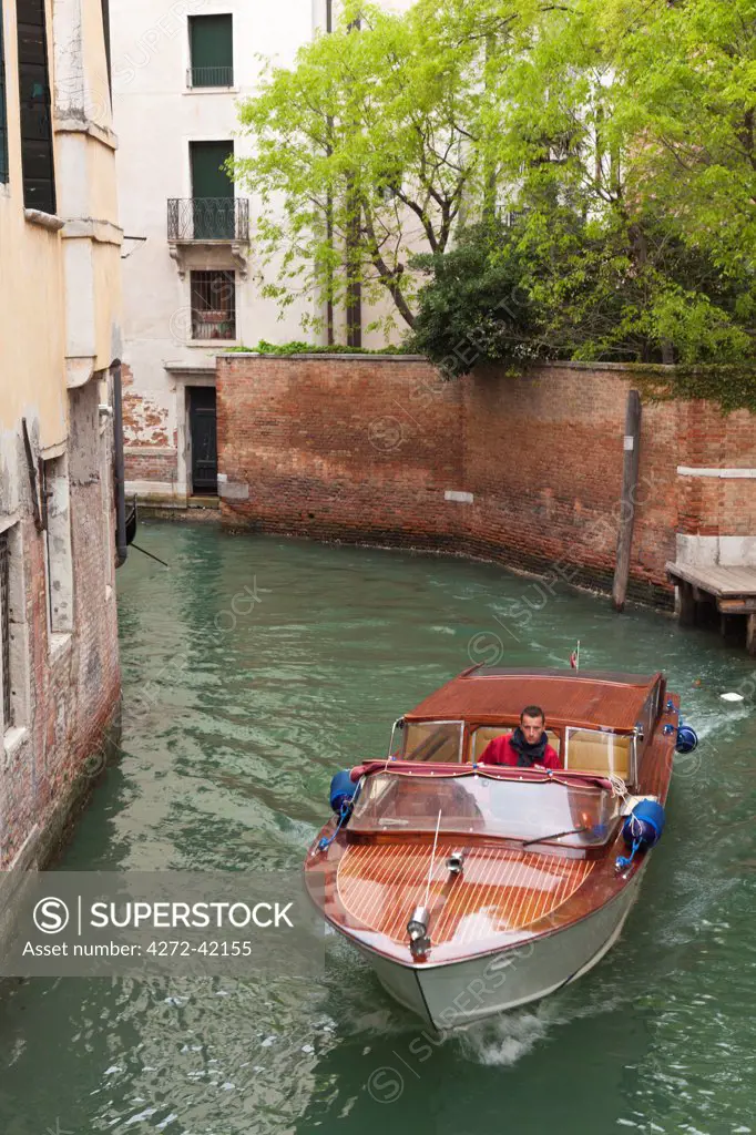 Europe, Italy, Venice. Pottering by boat through the back canals