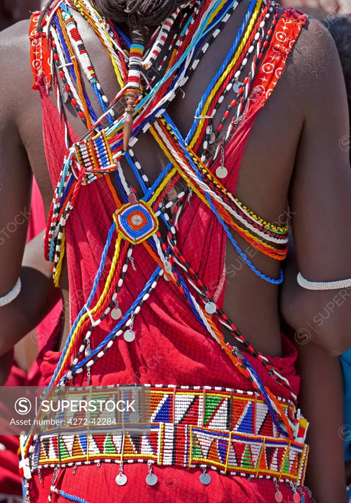 The beaded adornments of a Maasai warrior with the braids of his long ochred tied with leather to a small piece of decorated, hand carved wood called olkilorai, Kenya