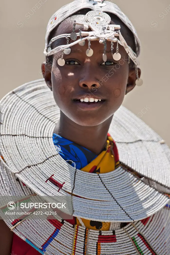 A young Maasai girl at Magadi. The circular markings on her cheeks as well as her white beaded ornaments denote that she is a Kisongo Maasai, Kenya