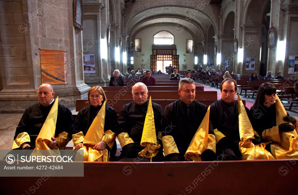 Santiago de Compostela, Galicia, Northern Spain, Men and women with their hoods in church before processions begin during Holy Week