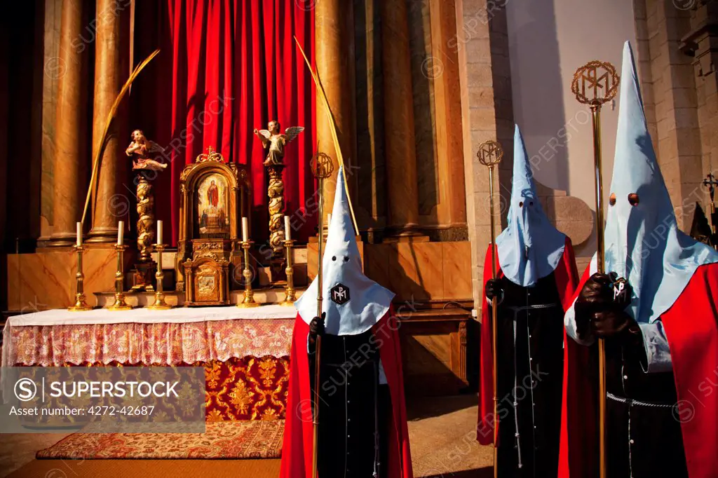 Santiago de Compostela, Galicia, Northern Spain, Nazarenos in front of the main altar in a church before a procession during Holy Week
