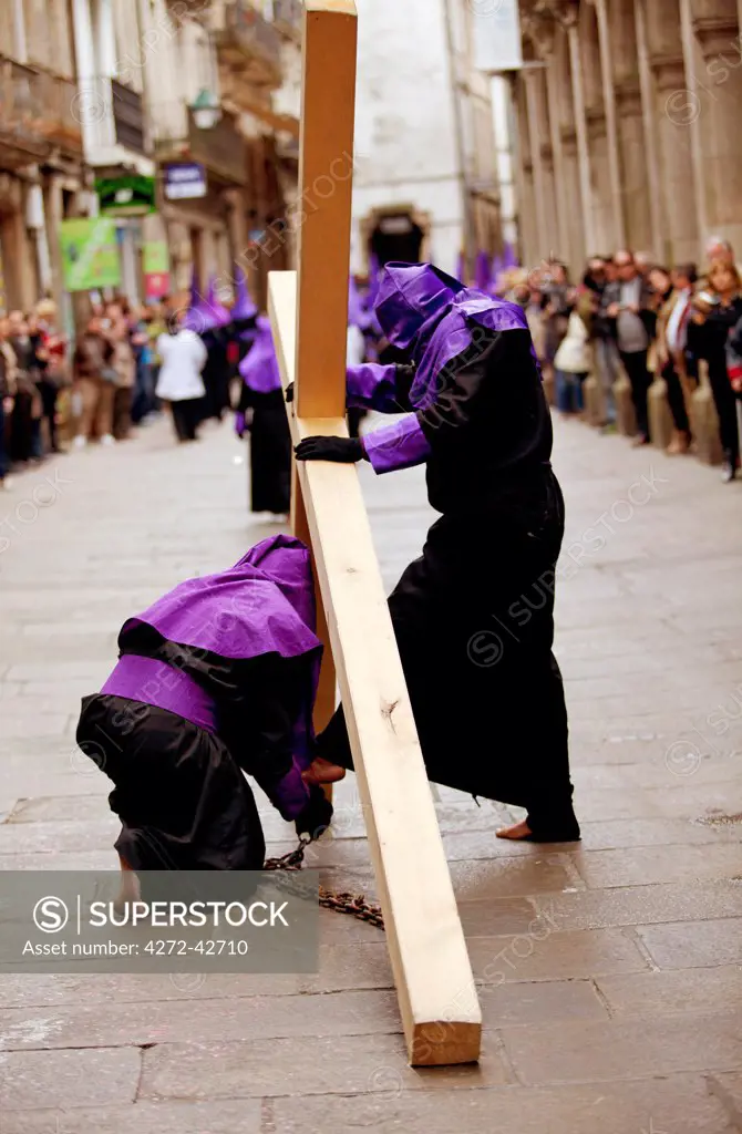 Santiago de Compostela, Galicia, Northern Spain, Bare foot Nazareners  carrying metal chains and cross during Semana Santa processions as a penitence