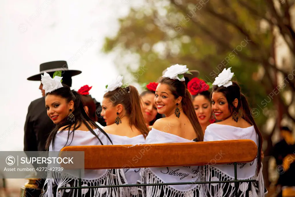 Seville, Andalusia, Spain, Young women on a horse drawn carriage during the Feria de Abril