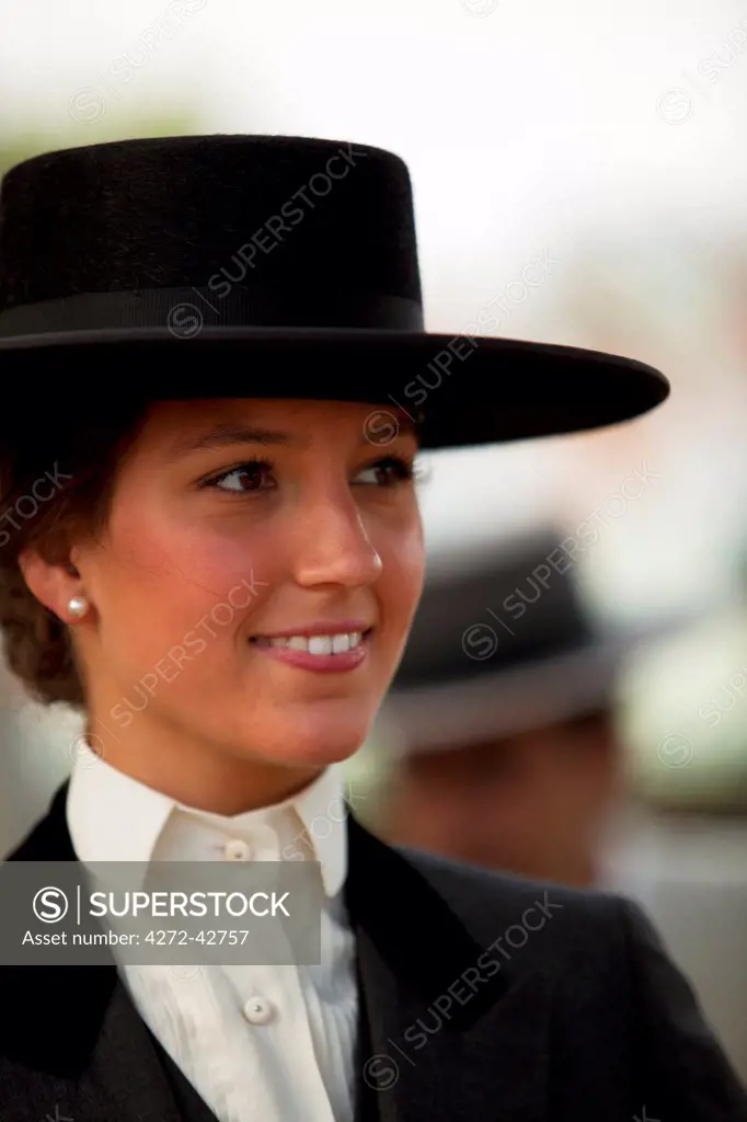 Seville, Andalusia, Spain, A young woman in horse riding clothes and sombrero during the Feria de Abril