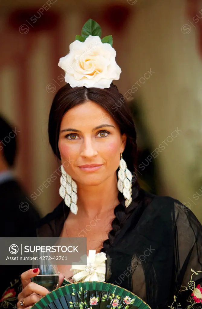 Seville, Andalusia, Spain, Portrait of a beautiful young woman in traditional clothes during the Feria de Abril